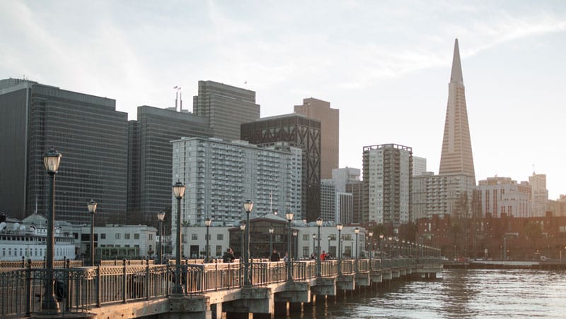San Francisco skyline view from the waterfront during sunset, showcasing downtown skyscrapers and iconic buildings like the Transamerica Pyramid. Perfect for real estate, urban development, and cityscape projects.
